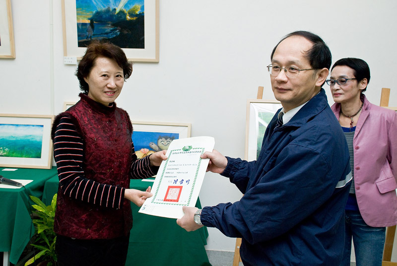 由學員代表接受進修部翁主任所頒發的結業證書