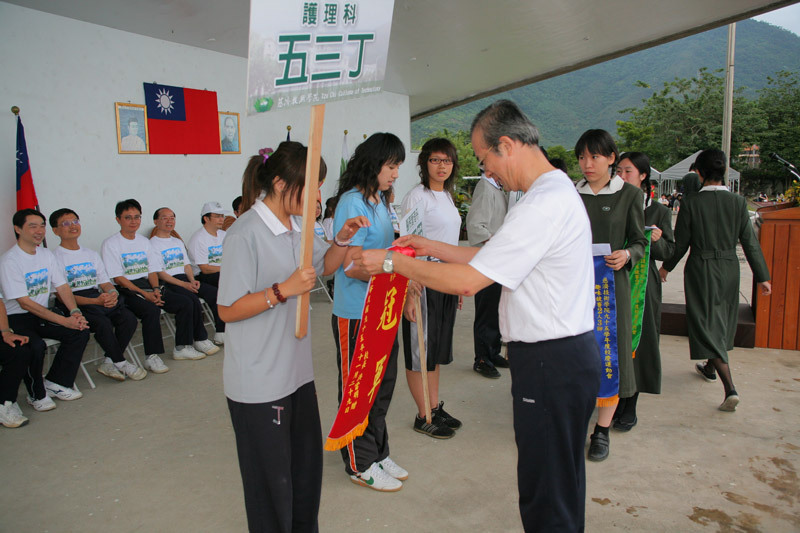 校長頒發100公尺男子組優勝學生獎杯